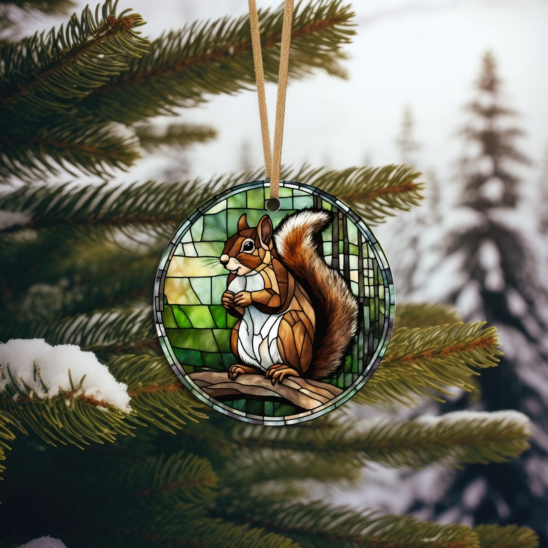 May include: A stained glass ornament featuring a squirrel sitting on a branch. The squirrel is brown and white with a bushy tail. The background is a green and blue stained glass design.