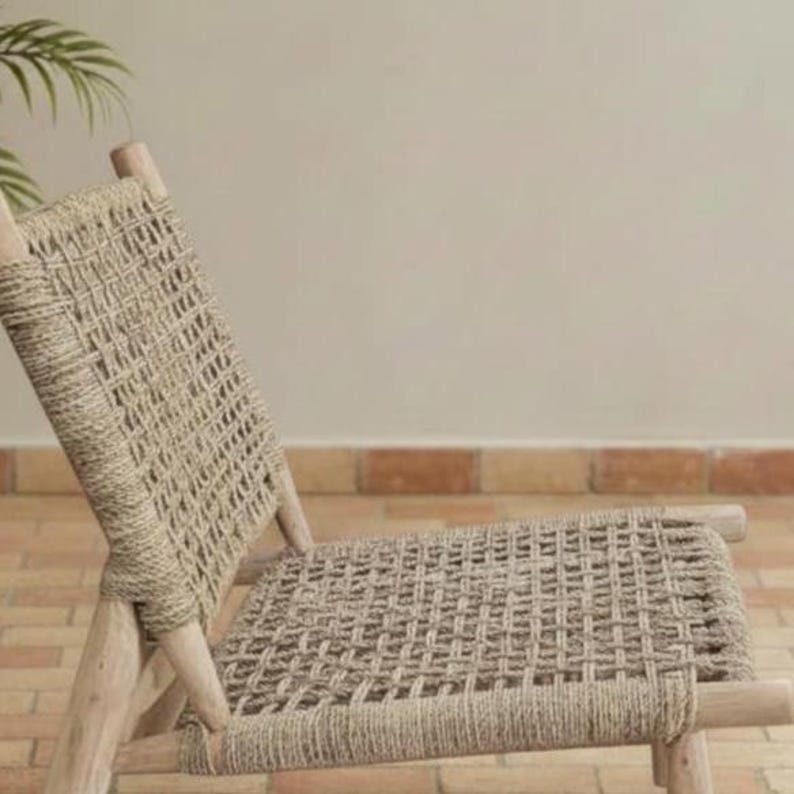 May include: A woven chair with a light brown, natural fiber seat and backrest. The chair has a wooden frame and a woven design. The chair is designed for relaxation and is suitable for indoor or outdoor use.
