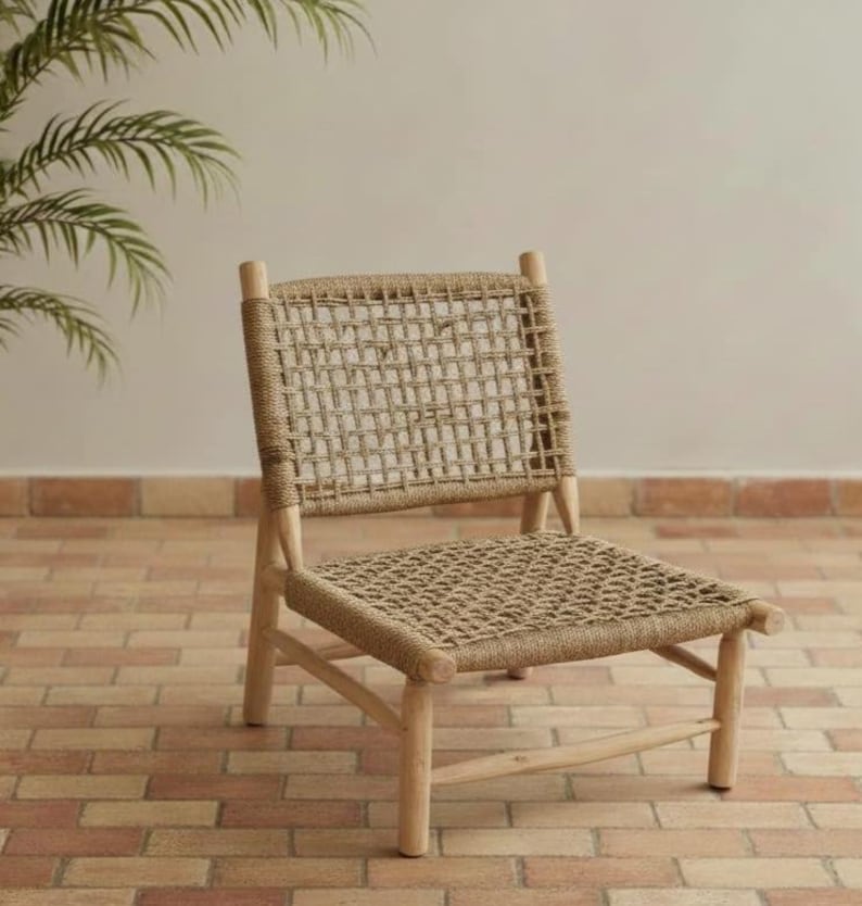 May include: A light-colored wooden chair with a woven seat and back. The chair has a rectangular back and seat made of a natural fiber material. The legs and frame are made of light-colored wood.