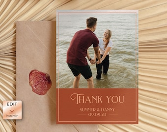 May include: A thank you card featuring a photograph of a couple in the water. The card is brown with a copper border and the text "Thank You" in a script font. The couple's names and wedding date are printed below the text.