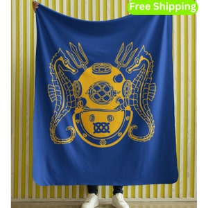 May include: Blue fleece blanket with a yellow diving helmet, two seahorses, and a trident design.