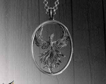 May include: A silver necklace with a round pendant featuring a detailed, three-dimensional phoenix design. The phoenix is depicted with its wings spread, facing forward, and its head tilted upwards.