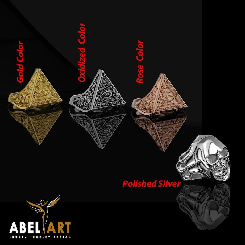 May include: A collection of rings in gold, oxidized, and rose colors, and a polished silver skull ring. The rings feature a pyramid design with an eye symbol. The brand logo "ABEL ART LUXURY JEWELRY DESIGN" is at the bottom.