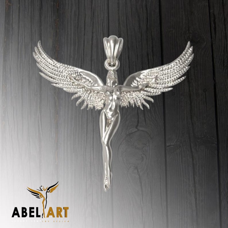 May include: Silver pendant featuring a detailed sculpture of a winged angel with outstretched arms. The angel is depicted in a standing pose with a flowing gown.