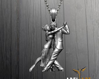 May include: Silver pendant necklace featuring a sculpted couple dancing the tango. The pendant depicts a man and woman in a passionate embrace, with intricate details. The necklace has a chain and a bail. The logo "ABEL ART LUXURY JEWELRY DESIGN" is visible.