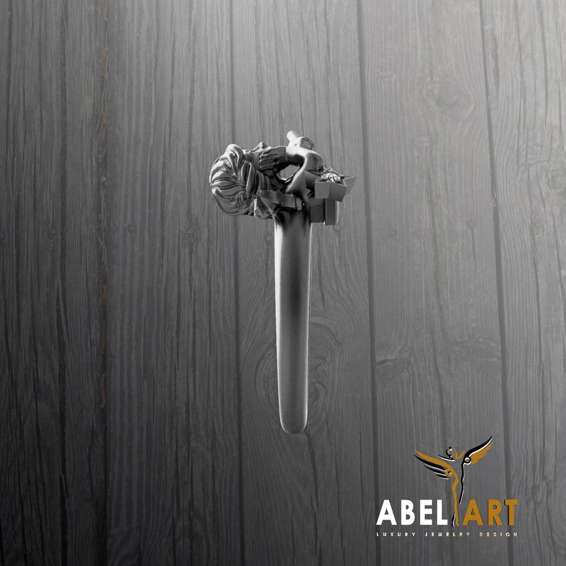 May include: A silver-toned ring with a detailed sculpture of a person on top. The ring's design features a long, cylindrical band. The background is a wooden surface. The logo "ABEL ART LUXURY JEWELRY DESIGN" is in the bottom right corner.