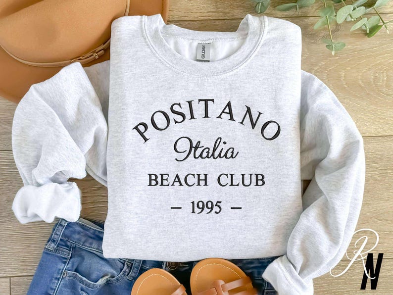 May include: Gray sweatshirt with black text that reads "Positano Italia Beach Club - 1995 -"