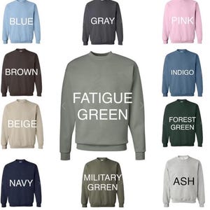 May include: A collage of 10 crewneck sweatshirts in various colors, including blue, gray, pink, brown, beige, navy, ash, indigo, forest green, fatigue green, and military green. Each sweatshirt has a color name printed on it.