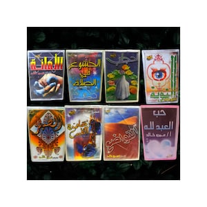 May include: Eight books with Arabic text on their covers. The covers display diverse designs, including illustrations of hands, figures, and abstract patterns. The books are arranged in two rows, with a dark green background.