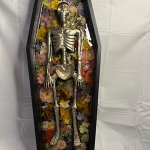 Arte de pared con ataúd florido