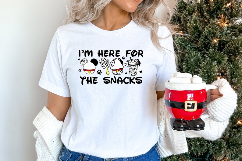 May include: White t-shirt with a black graphic that says "I'm here for the snacks" with a Mickey Mouse head, a dalmatian ice cream, a cupcake, and a coffee cup.