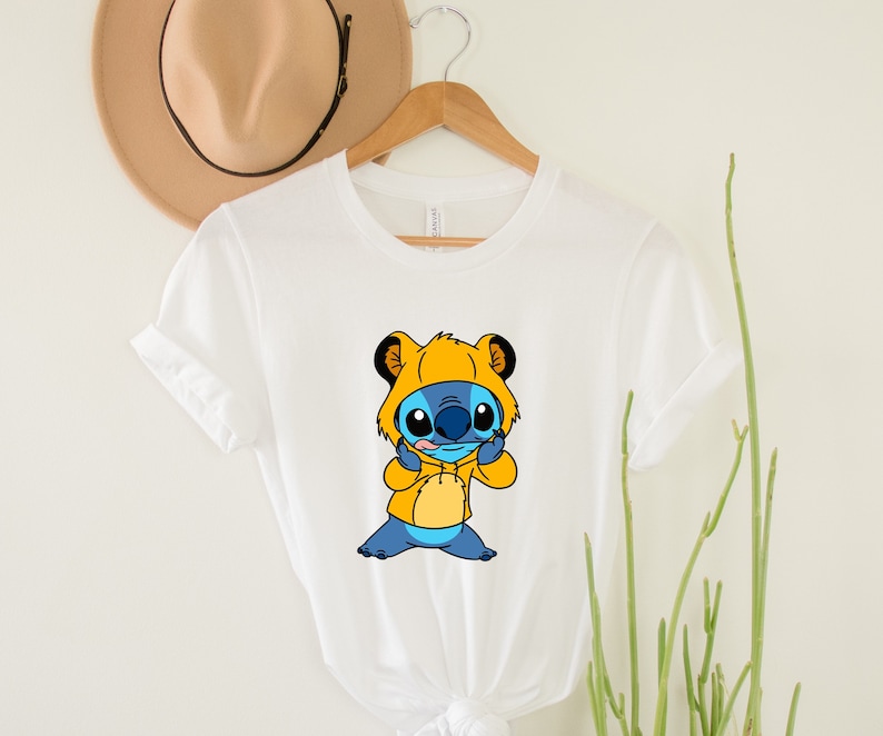 May include: White t-shirt with a blue Stitch character wearing a yellow hooded jacket. Stitch is making a silly face.