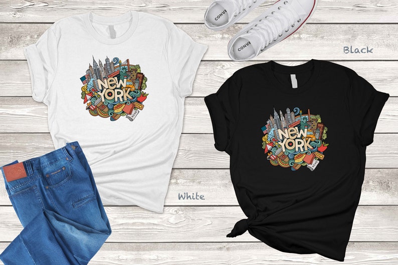 May include: Two t-shirts with a doodle design of New York City landmarks and the text "New York". The t-shirt on the left is white and the t-shirt on the right is black.
