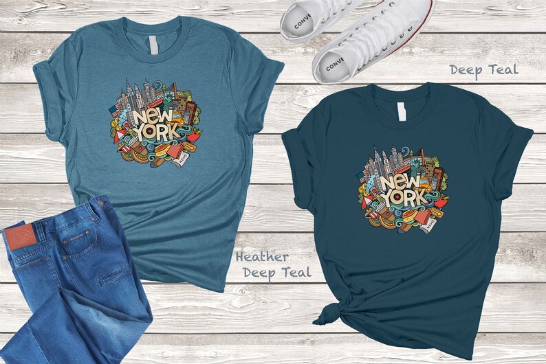 May include: Two t-shirts with a doodle design of New York City landmarks and the text "New York" in a circle. The t-shirt on the left is heather deep teal and the t-shirt on the right is deep teal.