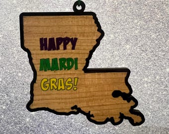 May include: Wooden ornament shaped like the state of Louisiana with the words "Happy Mardi Gras!" in green, purple, and gold.