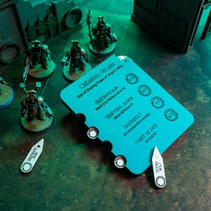 May include: A tabletop gaming scene featuring miniature figures and game components. A teal card with game instructions is in the center, with text like "Destiny's Run" and "Doombolt". Two white tokens and several miniature figures are also visible.