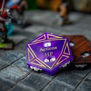 Puede incluir: Rastreador de juego de mesa morado y dorado con una etiqueta 'Actions HP' y los números 4 y 15.