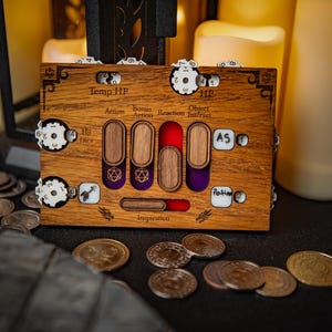 May include: A wooden tabletop game tracker with dials for tracking temporary hit points, hit dice, and inspiration. The tracker has slots for action, bonus action, reaction, and object interaction. The tracker is made of light brown wood with white and purple accents.