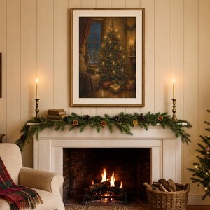 May include: A framed wall art print depicting a cozy room with a lit Christmas tree, presents, and a window view. The artwork is displayed above a white fireplace mantel decorated with a green pine garland, dried orange slices, and candles.