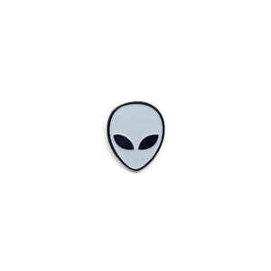 Peut inclure: Une petite broche en émail en forme de tête d'extraterrestre. La broche présente un visage gris clair avec une finition lisse et deux grands yeux noirs en forme d'amande. La tête est entourée d'un fin bord en métal noir, créant un contraste.