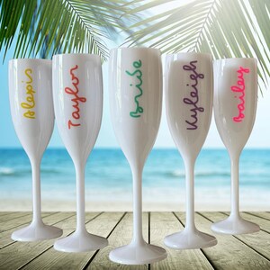 Personalized acrylic champagne flutes with custom Love Island inspired names and colorful vinyl decals. Lightweight reusable 5 oz flutes perfect for bachelorette parties, bridal showers, girls trips, birthdays, and party favors. Customized drinkware with tropical summer aesthetic.