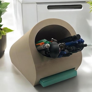 May include: A beige desk organizer with a curved opening for pens and pencils. The organizer has a small, light blue drawer on the bottom.