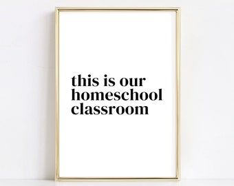 May include: A gold framed print with the text "this is our homeschool classroom" in black bold font on a white background.