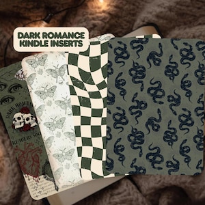 May include: Four rectangular Kindle inserts featuring Dark Romance Kindle Inserts text. Designs include a skull and heart graphic, a moth and skull pattern, a green and cream checkered print, and a dark green background with black snake illustrations.
