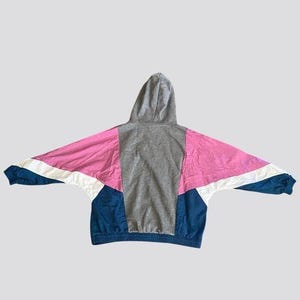 May include: A hooded sweatshirt with a color block design. The sweatshirt is gray, pink, white, and blue.