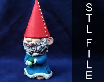 Può includere: Una piccola statuetta di gnomo con un cappello rosso, una barba bianca e vestiti blu. Lo gnomo tiene un piccolo oggetto verde nelle sue mani.