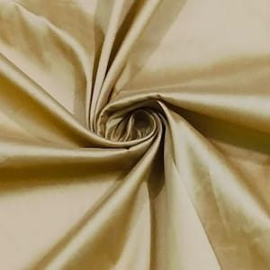 Könnte beinhalten: Nahaufnahme eines glatten, goldenen Stoffes mit seidenartiger Textur. Der Stoff ist drapiert und gefaltet, wodurch ein weicher, fließender Look entsteht.