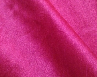 May include: A close-up of a smooth, pink fabric with a subtle sheen. The fabric has a slightly textured surface, giving it a luxurious feel.