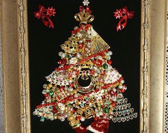 May include: A framed Christmas tree made of jewelry and other decorative items. The tree is decorated with red, green, gold, and white ornaments. The frame is gold and has a black velvet background.