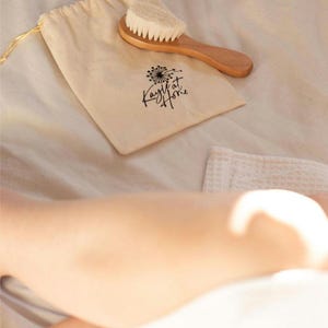 Kayle at Home facial dry brush, showing off its natural wooden handle and fine bristles for exfoliating delicate facial skin.