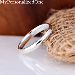 May include: A polished silver-toned ring with a smooth, rounded band. The text MyPersonalizedOne is visible in the upper left corner. The ring features a reflective metallic surface and a simple, circular design without any additional embellishments.