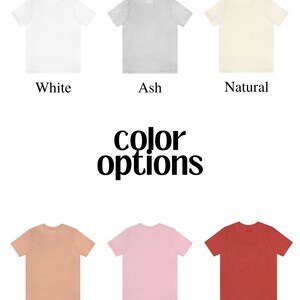 May include: Six different colour t-shirts, including white, ash, natural, heather peach, pink, and heather red. All the t-shirts are crew neck and short sleeve. The text "color options" is displayed below the top row of t-shirts.