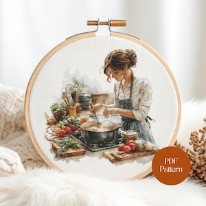 May include: Cross-stitch embroidery of a woman cooking in a kitchen, set in a wooden hoop. The scene includes a stove, vegetables, and cooking utensils. The woman wears an apron and is stirring a pot. The text "PDF Pattern" is in the lower right corner.