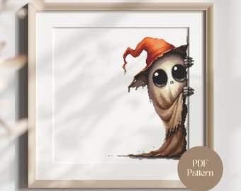 May include: Framed cross-stitch artwork showing a cartoonish figure with big eyes and an orange witch's hat, peeking from behind a dark surface. The image includes a PDF Pattern label.