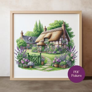 Peut inclure: Une impression encadrée à l'aquarelle d'un cottage pittoresque au toit de chaume, entouré de jardins luxuriants remplis de fleurs violettes et roses. Une porte verte mène à un sentier en pierre. L'impression porte une étiquette PDF Pattern.
