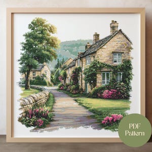 May include: A framed watercolor print of a quaint village scene. The artwork depicts stone houses with climbing plants, a pathway, and vibrant pink flowers. A large tree and a stone wall are on the left. The print is labeled "PDF Pattern".