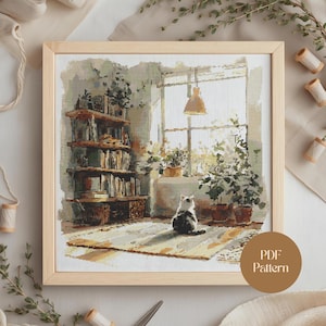 Op de afbeelding: Een ingelijst kruissteekpatroon toont een gezellige interieurscène. Een kat zit op een kleed voor een raam, met een boekenplank en potplanten. Het kunstwerk zit in een houten lijst, met de tekst "PDF Pattern" rechtsonder.