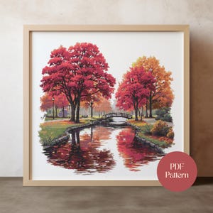 May include: Framed print of a park scene with a river reflecting the vibrant red and orange autumn trees. A small wooden bridge crosses the water. The print is in a light brown frame. A red circle with the text "PDF Pattern" is in the lower right corner.