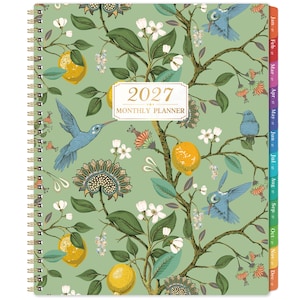 Op de afbeelding: Een maandplanner voor 2027 met een spiraalbinding aan de linkerkant. De kaft heeft een lichtgroene achtergrond met een botanisch patroon van gele citroenen, witte bloemen en blauwe kolibries. Een wit label in het midden vermeldt 2027 MONTHLY PLANNER.