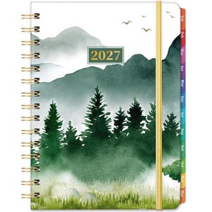 May include: A 2027 planner with a gold spiral binding and a gold elastic closure. The cover features a watercolour landscape of green pine trees, misty mountains, and birds in flight. The side includes colourful monthly tabs from January to December.