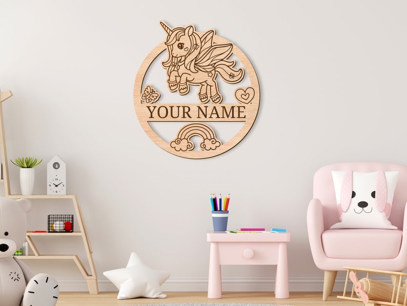 May include: A wooden round sign with a unicorn, rainbow, and clouds design. The sign has a space for a name, and the text "YOUR NAME" is visible.