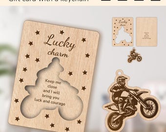 May include: A wooden gift card with a cutout of a motocross rider on a dirt bike. The card reads "Lucky charm" and "Keep me close and I will bring you luck and courage".