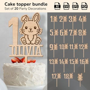May include: A cake topper bundle with 20 party decorations. The toppers are made of light brown wood and include numbers 1-18 with bunny designs, plus a topper with a bunny and the name "Olivia". The cake is white with strawberries.