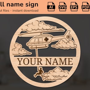 Op de afbeelding: Een rond, lasergesneden houten bord met een helikopter en een persoon die er vanaf abseilt. Het bord heeft de tekst "YOUR NAME" in het midden.