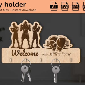 May include: Wooden key holder with boxing-themed silhouettes and gloves. The design includes the text "Welcome to the Millers house" and key hooks. The image also shows the text "Key holder" and "laser cut files - instant download".