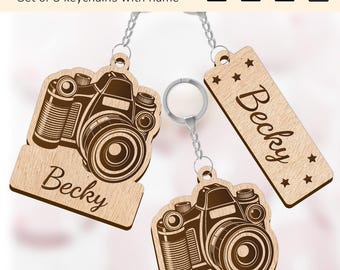 May include: Set of three wooden keychains featuring a camera design with the name "Becky" engraved on each. The keychains are made of light brown wood and have a silver metal ring.